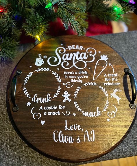 "Add a touch of magic to your Christmas Eve with our personalized round reindeer carrots milk cookie for Santa tray. This charming wood board doubles as a serving tray and a delightful Christmas cookie treat display. The tray features a festive design with black metal handles, perfect for carrying and showcasing your favorite treats. Choose from two sizes: the 15\" tray measuring 15\" round x 1\" thick (3\" with handles) or the 18\" tray measuring 18\" round x 1\" thick (3\" with handles). Get ready to impress Santa and create unforgettable memories with this enchanting tray. Handmade and finished in your choice of paint or stain then sealed with a polyacrylic finish for durability.  Trays are personalized with your child's name in white permanent vinyl." Santa Cookies Tray, Santa Tray Wood, Santa Trays, Santa Cookie Tray, Milk Tray, Round Wooden Tray, Red Mahogany Stain, Santa Tray, Round Wood Tray