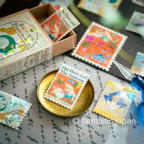 The 'Jewels of Fairy Tales' series is a colourful depiction of the world of fairy tales by Shinzi Katoh. This is the second edition of Kirapika Flake sticker series, an antique-style case filled with postage stamp-shaped flake stickers. The surface od the box and sticker surfaces are coated with a transparent hologram to create a jewel-like shine. The design of the box is inspired by the binding of a book, so you can enjoy collecting them as if they were arranged on a bookshelf. They are palm-sized and cute enough to carry around in a pen case or pouch. details -box size: 60mm45mm18mm -each sticker size : (large)45mm35mm, (small)35mm25mm -30 sheets (10 patterns   each 3 sheet -made in Japan Shinzi Katoh, Tales Series, Match Box, Pen Case, Postage Stamp, Sticker Collection, Sticker Book, Sticker Art, Box Design