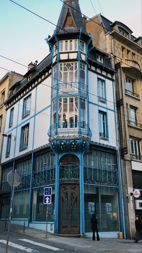 A three storey building on a street corner. It is in the art nouveau style with blue metal trim on the façade Noveau Art Architecture, Art Nouveau Exterior Architecture, Medieval French Architecture, Art Nouveau Greenhouse, France Architecture, Art Nouveau Architecture Paris, Nancy France, Slow Travel, Art Nouveau Style