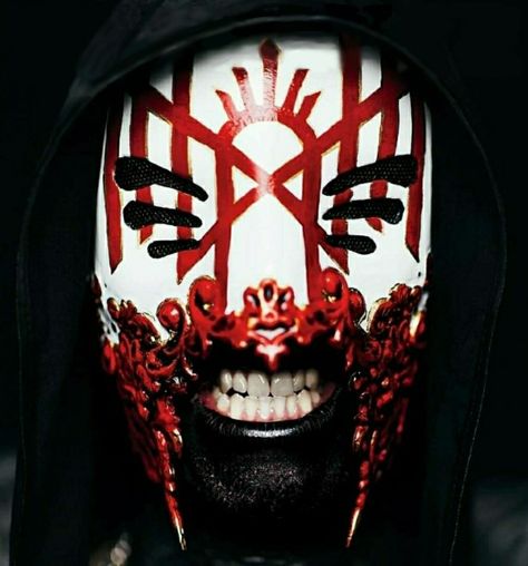 A photo of the masked singer of Sleep Token, Vessel, wearing his mask that has 6 eye holes and the Sleep Token logo in red. The mask also has bloody red Victorian shapes on the bottom of the mask. Vessel's teeth are visible and he has charcoal black body paint on. The background and his hood are black, almost pitch black. Sleeping Guys, I Love Sleep, Sleep Token, Mask Drawing, Ford, Sleep, Mask, Magazine, Makeup