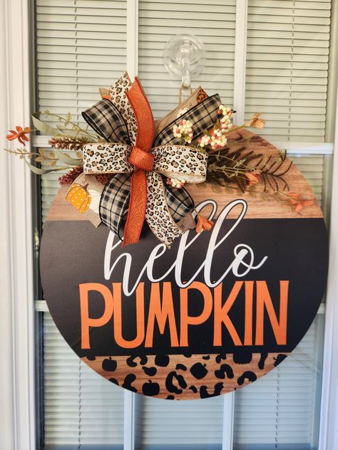 Say hello to fall in style with this gorgeous "Hello Pumpkin" door hanger, perfect for celebrating the autumn season!  This handmade wreath features a stunning mix of plaid, leopard print, and vibrant orange ribbons tied in a large bow, creating the perfect seasonal welcome for your home.  The bold "Hello Pumpkin" lettering is surrounded by chic leopard print and charming pumpkins, giving your front door the perfect mix of rustic and modern flair. Crafted with care, this door hanger combines sea Hello Fall Door Hanger, Fall Door Hangers Wooden, Pumpkin Lettering, Rustic Front Door Decor, Rustic Front Door, October Ideas, Fall Decor Diy Crafts, Fall Door Hanger, Pumpkin Door Hanger