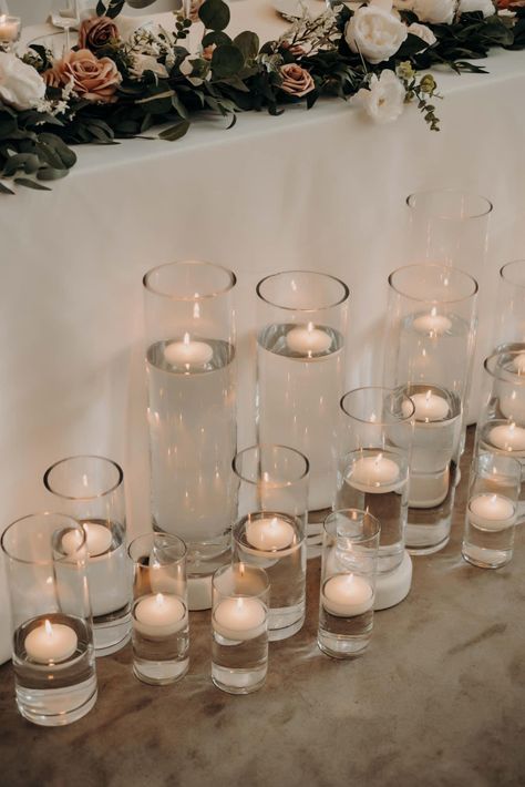 Tea Light Candles In Water, Cluster Of Candles Centerpieces, Vase With Water And Candle, Sweetheart Table Floating Candles, Cylinder Vases With Floating Candles, Candles In Glass Cylinders, Candle Centerpieces Wedding Round Table, Cylinder Vase Centerpiece Wedding, Floating Candles Wedding Centerpieces