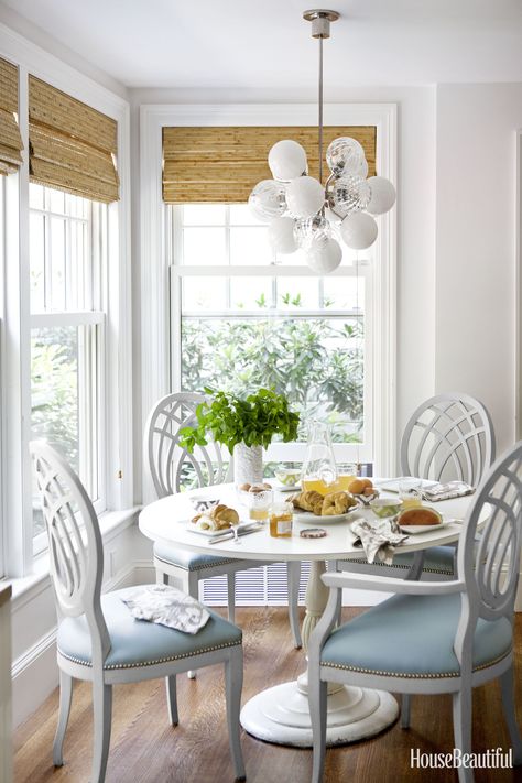 Interior decorator Laura Church Wilmerding paired a pedestal table from her childhood home with vintage dining chairs she found at the Stamford Antique & Artisan Center and had covered in S. Harris's Pivotal. The 1960s-style light fixture is Perle by Oggetti. Paul Raeside - HouseBeautiful.com Nook Furniture, White Round Dining Table, Table With Chairs, Coastal Dining Room, Kitchen Breakfast Nooks, Cottage Coastal, Cozy Breakfast Nook, Bedroom Curtain, House Of Turquoise