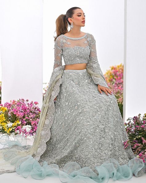 Immerse yourself in the celestial charm of our ice blue lehenga choli. The delicate choli and dupatta shimmer with opulent embellishments of sequins, Swarovski stones, and silver dabka, crafting a vision of timeless grace.This ensemble, a harmonious blend of tradition and modernity, promises to transform any bride into a vision of ethereal splendor. For more details contact us on our WhatsApp +1 (908) 257 5794 Visit our website www.rungmahal.com #bridaldressonline #bridalgown #usabridalgow... Ice Blue Lehenga, Ansab Jahangir, Blue Lehenga Choli, Pakistani Bridal Lehenga, Wedding Dresses Pakistani, Bridal Mehndi Dresses, Pakistani Bridal Dress, Walima Dress, Mehndi Dress