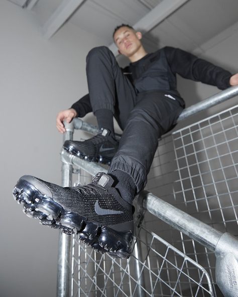 Stylish 2019 Nike Air Vapormax 3 sneakers in a black and dark grey colour. Man sitting on railings with black trackies showing Nike trainers. Dark Grey Colour, Vapor Max, Nike Vapormax, Nike Trainers, Man Sitting, Air Vapormax, Dark Grey Color, Nike Air Vapormax, Grey Colour