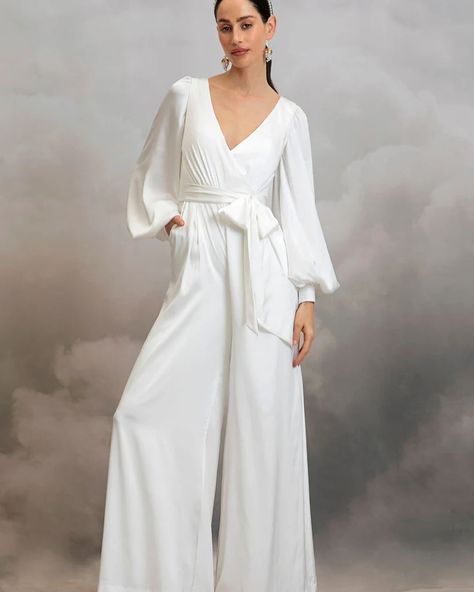 MIA JUMPSUIT by @catherine__deane — The Mia Jumpsuit is cut from luxurious eco satin. This classic bridal jumpsuit features a crossover, low V-front neckline, low V-back and long bishop sleeves with statement cuffs. Mia’s detachable waist sash cinches in the small of the waist for a figure flattering silhouette and her comfortable, wide leg trousers will see you dancing the night away in effortless ease! #bridalwear #bridaljumpsuit #jumpsuit #civilwedding #civilweddingdress #standesamt #we... Designer Overalls, Unusual Wedding Dresses, Catherine Deane, Wedding Dress Types, Bridal Kimono, Sleeved Wedding, Cape Wedding Dress, Civil Wedding Dresses, Satin Jumpsuit