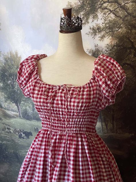 Be the countryside maiden of your dreams in this stunning Gingham Puff-Sleeve Maxi Dress. Featuring a fully-shirred bodice, bardot-style cinched milkmaid neckline, adjustable puff-sleeves, dainty bow-tied chest ribbon, and a sweeping half-circle skirt silhouette; this dress is the perfect summer-to-autumn uniform. From picking apples in the orchard, to baking pies in your cottage, this dress has you covered! Sizing: ✧IN✧ Bust Waist Hips Length S 28-42 In. 26-38 In. 80+ In. 45 In. M 32-44 In. 28- Milkmaid Dresses, Dress Aesthetic Vintage, Gingham Dresses, Baking Pies, Picking Apples, Milkmaid Dress, Countryside Cottage, Bardot Style, Apple Dress