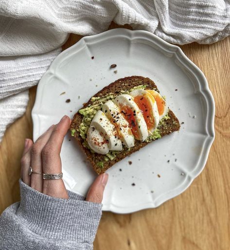 A girl holding a piece of avocado toast with a cut egg on top. Instagram Breakfast Pics, Almond Food, Wellness Foods, Instagram Pic Ideas, Lunch Dinner Recipes, Egg Lunch, 2024 Manifestation, Health Cooking, Avocado Toast Egg