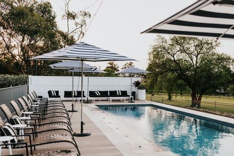 Resort style swimming pool surrounded by striped umbrellas, deck chairs and countryside at a private property available for wedding hire near Sydney. Wedding Venues Nsw, Sydney Wedding Venues, Greystone Estate, Private Property Wedding, Wedding Venues Sydney, Airbnb Wedding, Cheap Wedding Venues, Australian Wedding, Micro Weddings