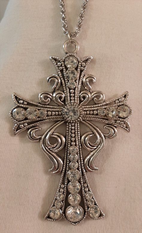 This silvertone necklace features a mid-to-large-sized pectoral cross with lots of life and movement!  It has a swirled curly-cue starburst aura and sparkles with faceted white/clear rhinestones that give it depth and character.  The reverse has a shiny finish and it measures 2 3/8 inches wide and 3 5/8 inches long.  The chain is 24 inches and closes with a safety catch. Gem Clothes, Mcbling Necklace, Clothes Accessories, Long Necklaces, Reverse Cross, Cross Chain, Estilo Punk, Jewelry Accessories Ideas, Dope Jewelry