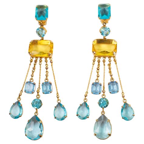 Sophisticated Carlo Zini dangling clip-on earrings. Features an extra-long shoulder-duster geometric shape with gilt metal framing ornate with dangling charms. Aquamarine, turquoise, and yellow topaz crystal rhinestones in pear, round and rectangular shapes. Marked at the back with Zini gilt metal tag. Measurements: 1.57 in. wide (4 cm) x 5.94 in. high (15 cm). Topaz Crystal, Metal Tag, French Jewelry, Art Ancien, Aesthetic Rooms, Handcrafted Artisan Jewelry, Earring Display, Accessories Jewelry Earrings, Pearl Earrings Dangle