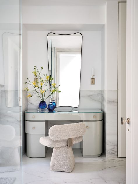 For the primary bathroom, Story designed a lacquered dressing table accented with a custom mirror and chair covered in a nubby fabric from Dedar. “It’s a little more glamorous, a little more refined, a little more special,” she says. The sconces are from Remains Lighting. Uptown New York, Peaceful Blue, Nyc Townhouse, Mahogany Paneling, Dressing Table With Chair, New York City Apartment, Leather Headboard, Blue Palette, Vanity Room