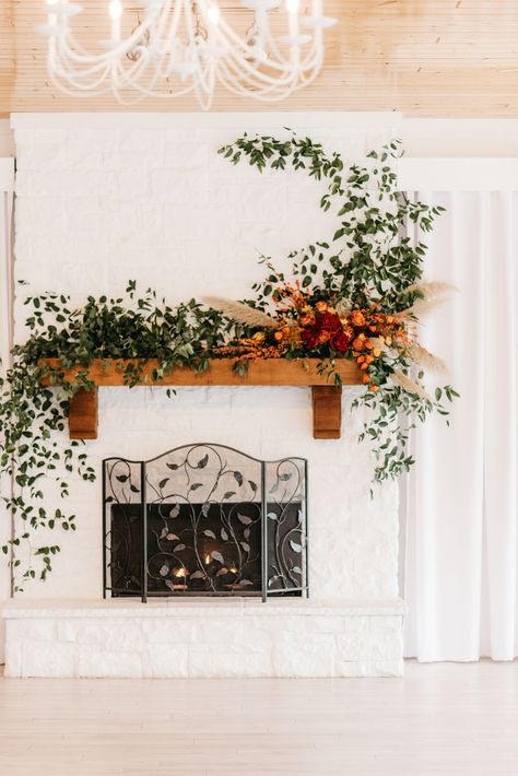 Smilax and fall flowers on white fireplace at Willow Creek Weddings. Mr. & Mrs. Archer Photography. Boho Wedding Fireplace Decorations, Wedding Backdrop Fireplace, Wedding Fireplace Mantle Ceremony Backdrop, Wildflower Fireplace Wedding, Boho Fireplace Mantle, Boho Fireplace Mantle Decor, Wedding Alter Fireplace, Wedding Fireplace Decor, Archer Photography