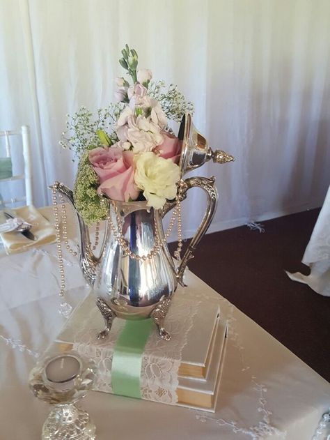 Delicate Elegance Events - Vintage wedding. Antique silver coffee / tea pot centerpieces on books covered with lace & ribbon Teapot Centerpiece, Tea Party Centerpieces, Vintage Wedding Centerpieces, Tafel Decor, Vintage Wedding Theme, Tea Party Decorations, Bridal Tea, Tea Party Bridal Shower, Wedding Vintage