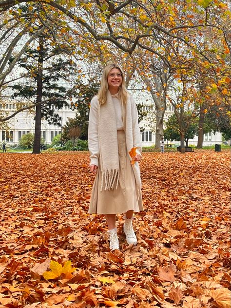 girl in autumn leaves wearing beige maxi skirt, white jumper, white scarf, and white boots ( converse heels ) instagram photo inspiration, autumn aesthetic, fall aesthetic, light academia outfit Beige Winter Skirt, Beige Skirt Fall, Alicia Jade Outfits, Winter Beige Flowy Skirt, Fall Beige Long Skirt, Cozy Fall Aesthetic Outfit, Winter Beige Knit Skirt, White Scarf Outfit, Cream Skirt Outfit