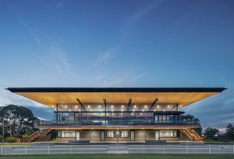 The Karen Rolton Oval Pavilion is a community sports hub located within the evergreen Adelaide Parklands. Designed to embrace and enhance the landscape, the pavilion fits within its setting while simultaneously standing out for its design. The building is slightly elevated allowing for the natural mounding of the ground to meet with ground floor - the upper level floating above. This maximises views to the sporting fields and timber lined roof, providing shelter and shade for patrons inside. T Sports Pavilion, Basketball Arena, Permeable Paving, Cricket Stadium, Sport Center, Cladding Systems, Metal Cladding, Architectural Practice, Water Collection