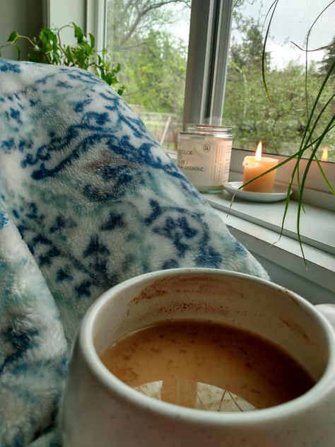 Cozy window seat overlooking a rainy sky. Candles lit in the window with plants lining the sides of the windowsill. Warm latte in lap with cozy blanket. Aesthetic weekend vibes/room decor & inspo. Calm Day Aesthetic, Rainy Day At Home Aesthetic, Rainy Spring Aesthetic, Cozy Spring Aesthetic, Cozy Rainy Day Aesthetic, Cozy Morning Aesthetic, Cozy Summer Aesthetic, Spring Nostalgia, Sleepy Vibes