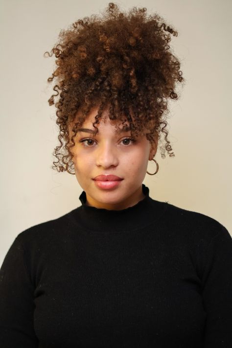 Medium lengh curly updo hairstyle. Black turtle neck and gold earrings Curly Bangs 4c Hair, Curly Hair Ponytail With Bangs, Curly Bun With Bangs Black Women, High Pony Curly Hair, Curly Afro With Bangs, Curly Hair High Ponytail, Curly Hair In Ponytail, Curly High Ponytail, High Curly Ponytail