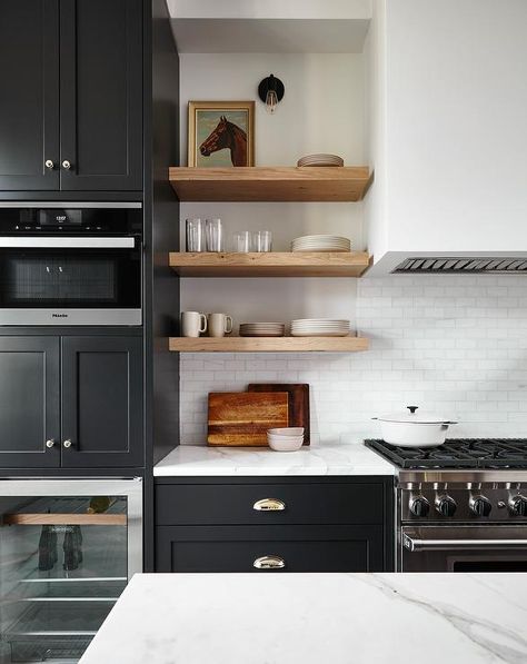 Stacked blond wood shelves flank a long white plaster range hood atop white marble subway tiles. Wood Shelves Kitchen, Creek House, Timber Shelves, Kitchen Post, Cripple Creek, Black Kitchen Cabinets, Physical Environment, Kitchen Upgrades, Mini Kitchen