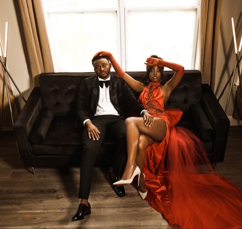 Red dress tuxedo engagement photo shoot wedding black sofa living room dress with slit dress with train Red Dress Couple Photoshoot, Black People Engagement Photos, Red Dress Engagement Pictures, Engagement Photos Red Dress, Red Engagement Dress, Black Sofa Living, Casual Engagement Photoshoot, Valentines Photos, Engagement Photo Shoot Poses