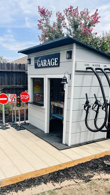 Toy Garage Outdoor, Outdoor Toy Garage, Boy Playhouse Outdoor, Kids Garage Playroom, Role Play Area Ideas, Boys Playhouse Outdoor, Playhouse Makeover For Boys, Garage Kids Playroom, Kids Outside Play Area