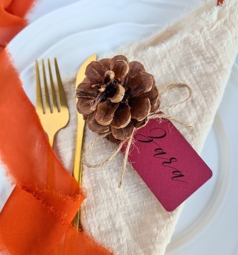 "Our bestselling pine cone place cards are the ultimate natural, rustic touch for your Autumn or Winter wedding tables. Our autumn place cards are available in a range of autumnal hues, printed to your guest list and arrive with you complete, ready to place onto your tables. No need for any DIY assembly or stands. They look beautiful as part of a wider rustic theme, autumn toned colour schemes or a winter wedding. Each place card is handmade in our Staffordshire studio using slightly textured, b Autumn Wedding Place Settings, Autumn Wedding Favours, Winter Wedding Table, Wedding Seating Cards, Wedding Place Names, Wedding Favors Fall, Autumn Table, Wedding Place Settings, Wedding 2025