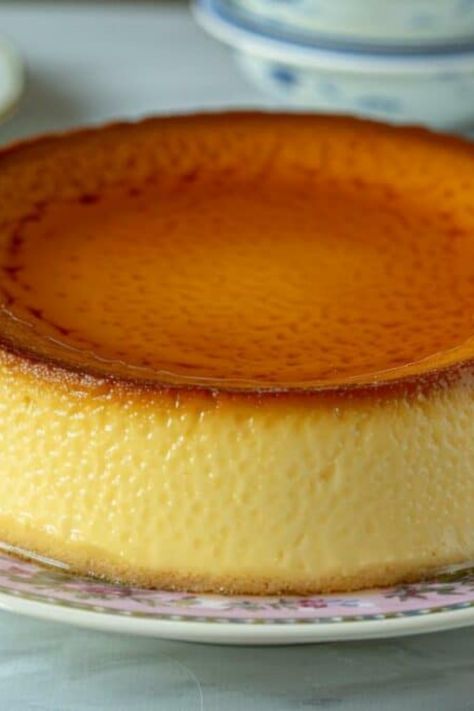 Un flan pâtissier sans pâte, doré et crémeux, est présenté sur une assiette décorative dans une ambiance de cuisine élégante. Dessert Simple, Flan, Nutella, Dessert, Natal