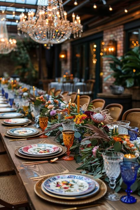 Step into a whimsical, bohemian wedding table set in a forest clearing, with reclaimed wood tables, vintage rugs, and a canopy of fairy lights. Eclectic greenery, mismatched china, and colorful glassware evoke a free-spirited vibe. #BohoWedding #EucalyptusGarland #WhimsicalWedding #VintageDecor #BohemianChic Indoor Bohemian Wedding, Eclectic Fall Wedding Decor, Mismatched Dinner Plates Wedding, Wedding Decor Ideas Colorful, Eclectic Wedding Inspiration, Mismatched Wedding Table Decor, Vintage China Wedding Reception, Fall Boho Chic Wedding, November Wedding Themes Color Schemes