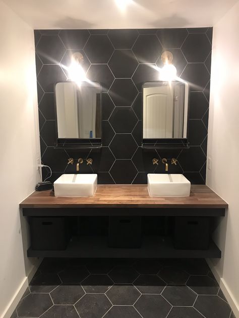 Black Hexagon Wall Tile, Black Tile Wood Vanity, Bathrooms With Black Hexagon Tiles, Black Honey Comb Tile, Black Hexagon Tile Bathroom Wall, Bathroom Black Tile Wall, Black Hexagon Tile Fireplace, Black Tile Half Bath, Black Vanity With Wood Top