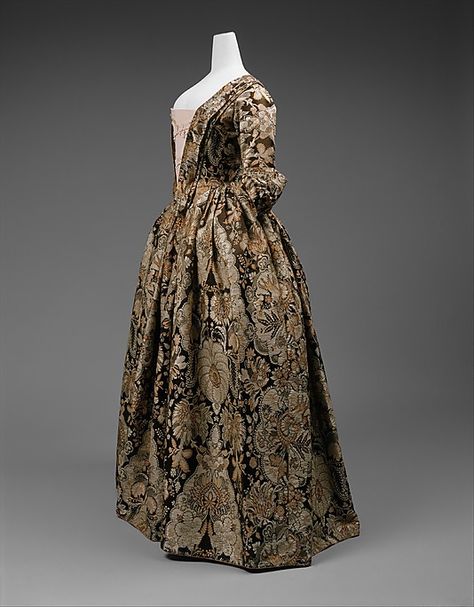 1735. British. Side front view. Heavy Spitalfields silk with lace pattern design woven in beige and rust on a dark brown satin ground. No signs of alteration.  (C.I.64.14). 1720s Fashion, 1730s Fashion, Historic Patterns, Vintage Frocks, 18th Century Dresses, 1700 Fashion, Victorian Dresses, Antique Wardrobe, 18th Century Dress