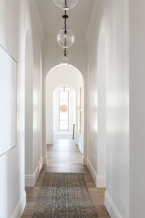 Left side mirrors down hallway hanging globes from entry to kitchen Upstairs Hallway Lighting, Studio Mcgee Hallway, Hallway Lights Ideas, High Ceiling Hallway, Hallway Pendants, Entry To Kitchen, Studio Mcgee Lighting, Hallway To Kitchen, Hanging Globes