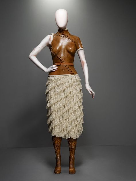 No. 13, spring/summer 1999  Corset of brown leather; skirt of cream silk lace; prosthetic legs of carved elm wood  Courtesy of Alexander McQueen Aimee Mullins, Beauty Exhibition, Alexander Mcqueen Savage Beauty, Prosthetic Leg, Savage Beauty, Mcqueen Fashion, Va Va Voom, Leather Corset, Corsets