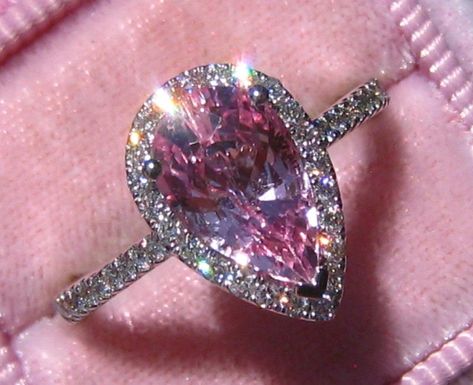 A beautiful and delicate engagement ring featuring a sparkly pink pear sapphire in white gold diamond halo. The center stone is a beautiful pear sapphire, that weighs 2.49 carats and measures 10.4x6.5mm. It is eye-clean, basic heat only and comes from Sri Lanka (Ceylon). It has a beautiful medium pink color, very nice cut and lovely sparkle! The sapphire is set in a 14K white gold ring with 0.3 carats of GH VS2 diamonds, that frame the stone in a delicate diamond halo. The ring is designed with Delicate Engagement Ring, Engagement Ring Mountings, Ceylon Sapphire, Dream Engagement Rings, Sapphire Engagement Ring, Rose Gold Engagement, Halo Diamond Engagement Ring, 14k White Gold Ring, Fantasy Jewelry