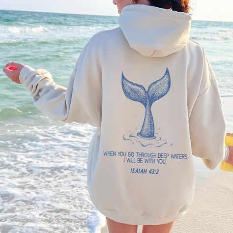 Dive into comfort and faith with our ocean inspired Isaiah 43:2 hoodie! With serene beach vibes & majestic whale motifs, this beachy bible verse hoodie is a testament to God's protection.. 🐋🌊 Perfect for devout Christians seeking comfort & style. Gift it to inspire loved ones! Order yours today!                                 ＊ 𝐍𝐎𝐓 𝐀𝐕𝐀𝐈𝐋𝐀𝐁𝐋𝐄 𝐈𝐍 𝐒𝐓𝐎𝐑𝐄𝐒 ＊ 👚 GET TO KNOW YOUR  WHEN YOU GO THROUGH DEEP WATERS HOODIE This When You Go Through Deep Waters Hoodie is printed on a Gildan 18500 Unisex Heavy Blend Hoodie with ink using a direct-to-garment printer. They will print your item and send it right to your door!  ✽ 50% Cotton 50% Polyster  ✽ Medium-heavy fabric (8.0 oz/yd² (271.25 g/m  ✽ Classic fit tubular body  ✽ Unisex Sizing  ✽ Runs True to size ◄ 𝗦 𝗜 𝗭 𝗜 𝗡 𝗚 Cute Hoodie Designs, God Hoodies, Hoodies Ideas, Beachy Clothes, Christian Outfits, Isaiah 43 2, Christian Clothes, Beach Hoodie, Ocean Style