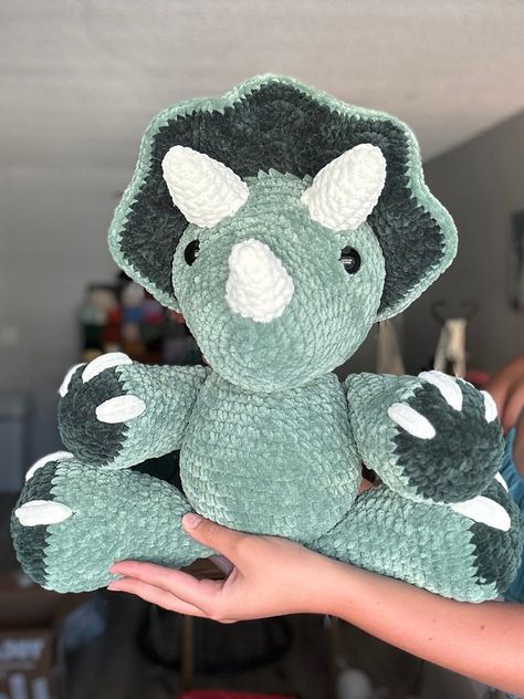 An adorable green colored triceratops! made with size 6 sweet snuggles lite yarn. pattern is tanner the triceratops by nichole chase! This dino sits at 16 in and stands at 20 in! Crochet Dino Triceratops, Crochet Land Before Time, Colorful Crochet Animals, Crochet Strawberry Dinosaur, Crochet Chunky Dinosaur Pattern Free, Green Crochet Plushies, Crochet Triceratops Free Pattern, Triceratops Crochet Pattern Free, Tanner The Triceratops