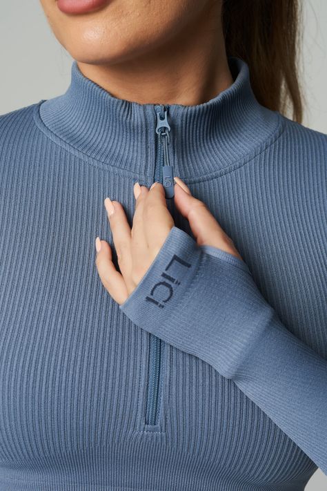 Customize your climate with the Seamless Ribbed Long Sleeve Half Zip. With long sleeves and a mock neck, this fitted pullover is exactly what you need for warm ups, cool downs and the stretches in between. The perfect fusion of performance and comfort. Our ribbed long sleeve is made from ultra-soft, premium fabric that is made to last. Full Coverage Double Lined Ribbed Fabric Half Zip Mock Neck Cropped Length Thumb Holes Ribbed Band Detail for Extra Support LiCi Logo placement center top back an Activewear Fabric Texture, Long Sleeve Activewear Tops, Sports Wear Outfits, Sporty Sweater, Gymwear Outfits, Running Wear, Logo Placement, Rib Fabric, Easy Trendy Outfits