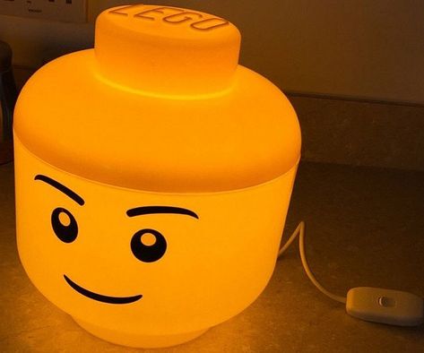 Animate your kid's bedroom with some quaint ambient lighting provided by this LED LEGO head lamp. Made from polypropelene, it is fitted with a 9W LED bulb that emits a warm yellow glow that's as inviting as its joyful smile. Lego Room Ideas, Lego Lamp, Batman Bedroom, Lego Room Decor, Lego Bedroom, Lego Decorations, Lego Head, Lego Table, Lego Room