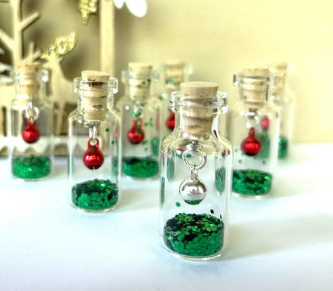 Buy any 5 bottles, get 20% off total order. Use code SAVE20 Please message us if you would like a ribbon for hanging. These tiny bottles are super fun! Holiday themed with your choice of bell and glitter! Please let us know in messages if you would like a metal loop and ribbon for hanging. The bottle measures approximately 5/8 by 1 1/2 inches.  These are repurposed bottles which we clean so keep in mind they're not perfect. Some have small spots or tiny scratches but are only visible if you look Diy Bridal Gifts, Mini Glass Bottle Crafts, Mini Glass Bottles Ideas, Small Glass Bottle Crafts, Repurposed Bottles, Tiny Bottles, Diy Glow, Tiny Jars, Christmas Arts And Crafts