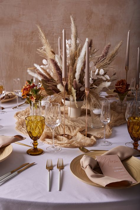 Embrace the popular boho chic trend with this stunning tablesetting. The earth tones of the pampas and dried flowers in the centrepiece are paired well with the beige napkins, taper candles and gold accents. This creates a beautiful neutral look, perfect for birthdays, dinner parties and weddings. 

#TableDecoration #TableSTyling #WeddingInspo #Boho #Weddingtable #WeddingDecor #Partyideas #Dinnerideas #Weddingreception #Bohochic #Earthtones #Floralarrangement #Neutraltones Xmas Table Decorations, Neutral Christmas Decor, Boho Christmas, Candle Centerpieces, Wedding Flower Arrangements, Taper Candles, Christmas Candles, Event Styling, Earth Tones