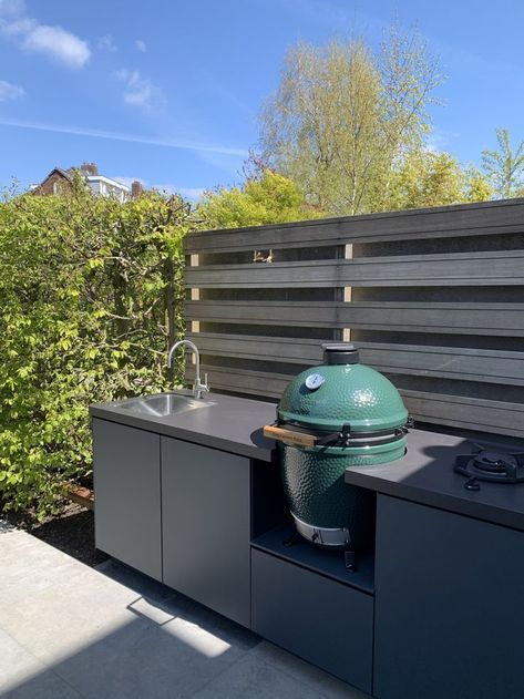 Een moderne buitenkeuken, voorzien van alle gemakken met een centraal opgestelde Big Green Egg barbecue. Genieten!