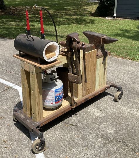 This cart has many of the items needed in a blacksmith shop. it can be moved when needed. Once it is in place, it is lowered to the ground so that the wood stand is in contact with the ground. It is hard to see in the photo, but there is a swage block between the post vise and the anvil. The wheels are from electric wheelchairs, so they are very heavy duty. The next improvement will be tool storage. Homemade Forge, Diy Forge, Blacksmith Workshop, Gas Forge, Forging Tools, Welded Metal Projects, Blacksmith Forge, Metal Fabrication Tools, Blacksmith Tools