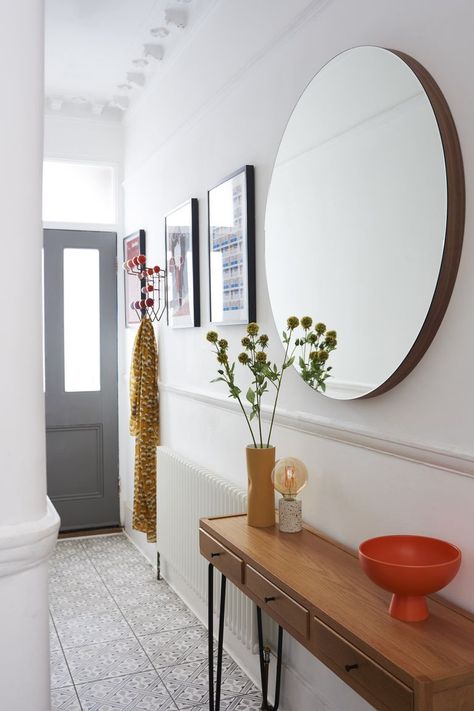 In a small and narrow hallway, bounce as much light around as possible with mirrors and by zoning your space. To avoid it feeling cramped and cluttered, create the illusion of space by adding mirrors which will reflect light, making the space seem wider and brighter. A slim, narrow console table is also ideal for the landline phone, some flowers and a bowl for keys. Get more hallway decor ideas at housebeautiful.com/uk. (Photo: Heal's) Hallway Decor Ideas, Hallway Table Decor, Entrance Hall Decor, Hallway Mirror, Hallway Inspiration, Flat Decor, Narrow Hallway Decorating, Narrow Hallway Ideas, Hallway Flooring