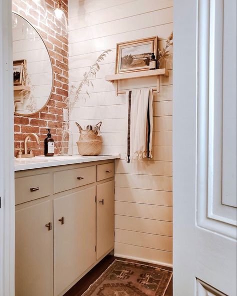 Shiplap and brick tiles were added to this farmhouse bathroom to create a more modern feel all while using elements that are found in the original architecture! Soft colors, natural wood custom built shelves and brass accents really pop against this beautiful brick wall. Brick And Shiplap Wall, Brick Bathroom Ideas, Brick Bathroom Wall, Brick Wall Bathroom, Brick And Shiplap, Brick Tiles Bathroom, Powder Room Update, White Powder Room, Brick Bathroom