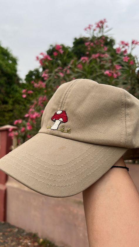 Cute little embroidery of mashroom and some grass on beige cap, i have used anchor threads of different shades fro some shadow effect #mushroom #handembroidery #baseballcap #embroidedcap #mushroomembroidery #embroideryideas Hand Embroidery Cap, Embroidered Hat Ideas, Mushroom Merchandise, Cap Embroidery Ideas, Embroidered Hats Ideas, Beige Cap, Embroidery Jeans Diy, Cap Embroidery, Shadow Effect