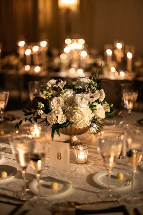 Gold scallop edge compote with a winter white centerpiece - including touches of white anemone. Votive candles to surround. PC: Ann Coen https://www.anncoen.com/photography White Rose Centerpieces, 21 Party, White Floral Arrangements, Event Business, White Centerpiece, Nye Wedding, 21st Party, White Anemone, Rose Centerpieces