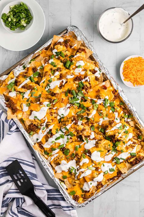 Chili Nachos topped with a creamy cheese sauce, cilantro sour cream, and green onions is a great way to use up leftover chili. Chili Nachos Recipe, Leftover Chili Recipes, Baked Chili Cheese Dogs, Gameday Snacks, Chili Cheese Nachos, Nachos Recipes, Chili Nachos, Green Onions Recipes, Ground Beef Chili