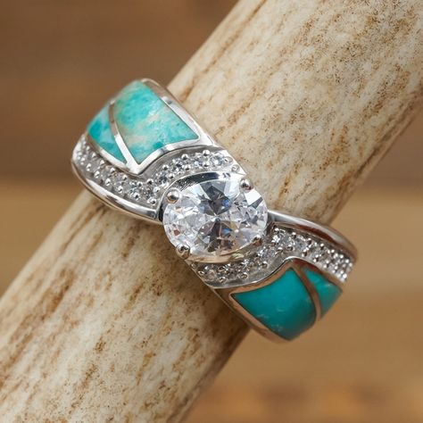 Indulge in the stunning beauty of THE GRENADA - a ring that exudes natural elegance! Make a statement and turn heads with this eye-catching accessory. ABOUT THIS RING Metal: 925 Sterling Silver, Rhodium PlatingColor/Finish: Turquoise Inlay & Silver, PolishedStone Size: 6.9mm Oval Cubic Zirconia Center Stone & 0.7mm Round Cubic Zirconia stonesBand Width: 8.6mm Antler Rings, Western Things, Turquoise Wedding Rings, Antler Wedding Band, Antler Ring, Turquoise Wedding, Engagement Sets, Sparkly Things, Right Hand Rings