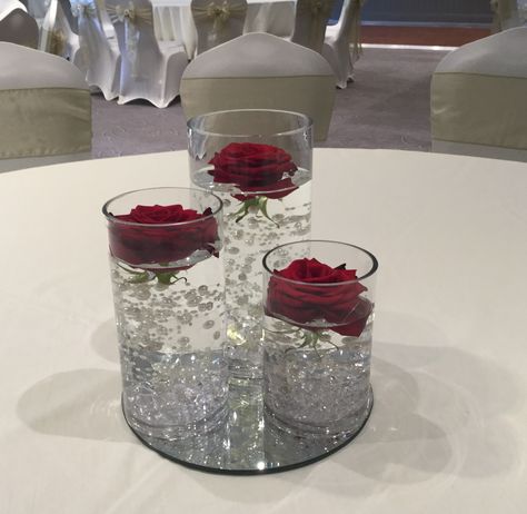 Centerpieces With Mirrors, Cylinder Vase Decor Wedding, Red Cylinder Vase Centerpiece, Fairy Lights In Cylinder Vase, Cylinder Vase Decor, Glass Vase With Flower Ball Centerpiece With Twinkle Lights, Red Roses And Pearls Centerpieces, Roses In Water Centerpiece Floating Candles, 25th Wedding Anniversary Decorations