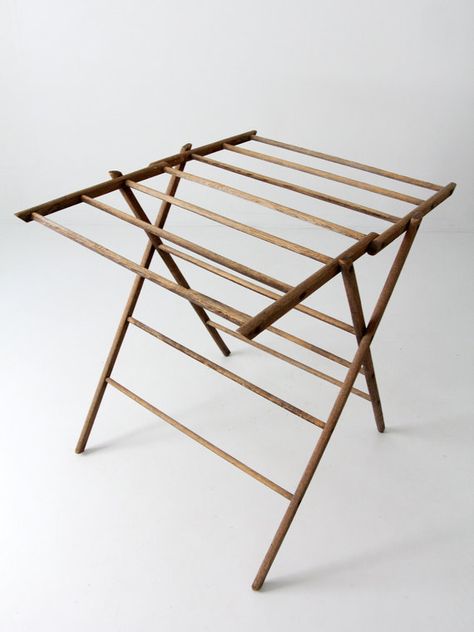 antique drying rack  A rare find! This antique wood drying rack features a unique fold-up top that can be used stretched out flat or hung at an angle. The rack features multiple spindle bar hangs that are screwed into the wood frame. The rack fully collapses for easy storage. It is a beautiful utilitarian piece. ○ wood rack ○ collapsible  CONDITION In good, aged condition with wear consistent with age and use. There is rusting to the screws, and general light wear and patina to the wood.  MEA... Antique Drying Rack, Wooden Clothes Drying Rack, Laundry Stand, Folding Clothes Drying Rack, Wooden Drying Rack, Drying Rack Laundry, Drying Racks, Wood Rack, Clothes Drying