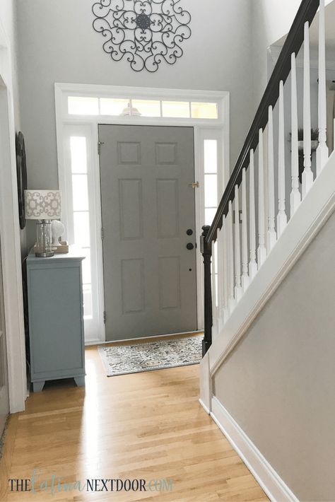 Welcome home to your favorite new foyer color combo. Sticking with warm, inviting neutrals, Yami from @yamithelatina painted her front door just a few shades darker than the walls then set them apart with white, bright trim. Want this look in your home, too? Go with walls in Repose Gray SW 7015, trim in Extra White SW 7006 and a door in Pussywillow SW 7643. Entryway Staircase Paint Colors, Painting Bannister, Foyer Paint Colors Entryway, Front Door Interior Color, Painted Stair Railings, Foyer Colors, Entryway Paint, Foyer Paint Colors, Painting Rooms